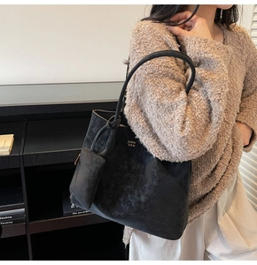 Detail of vintage black matte tote bag with matching zippered pouch on shoulder
