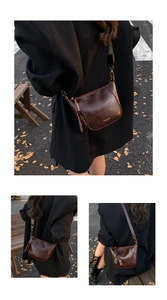 Detail of vintage brown leather crossbody bag with wide strap and embossed brand logo
