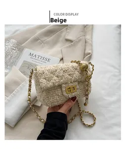 Detailed close-up of beige tweed texture and golden metal twist lock on a mini crossbody bag