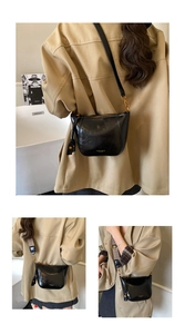 Detail of black leather saddle bag with interchangeable wide woven shoulder strap