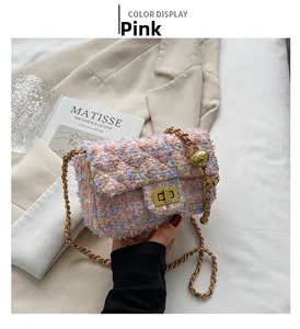 Detail of pink tweed chain bag with gold rotary lock and decorative gold ball charm