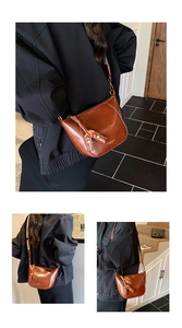 Detail view of a vintage brown crescent bag with wide jacquard strap and gold hardware