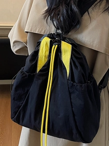 Minimalist black nylon drawstring backpack with yellow contrast details for women