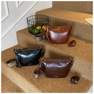 Detail view of retro saddle bags in black and brown with glossy finish and wide straps