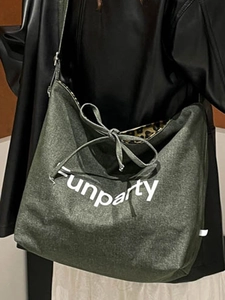 Green canvas tote bag with white lettering and leopard print lining shown on shoulder