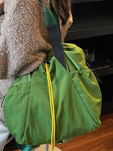 Minimalist green nylon large capacity shoulder bag with yellow drawstring detail for women