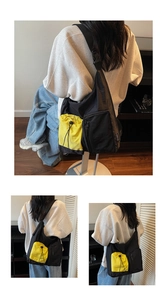 Detail of fashion crossbody bag with vibrant yellow drawstring pocket and nylon fabric
