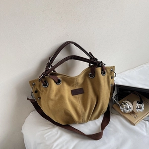 Detail of ginger canvas tote bag with brown straps, metal eyelets and laptop lifestyle setup