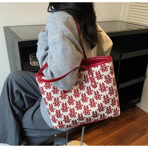 Detail view of woven Xi character patterns on a red and white festive tote bag