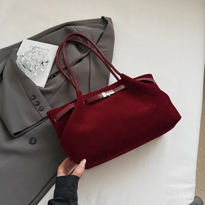 Detail of burgundy matte bucket bag with long leather straps and metallic buckle detail