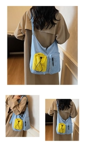 Detail of blue nylon crossbody bag featuring contrast yellow drawstring pocket and zipper