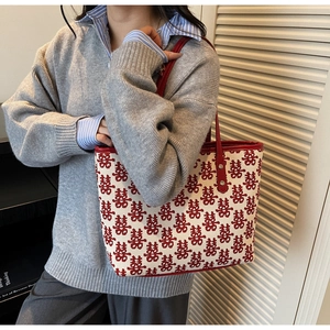 Detail showing red leather handle and double happiness jacquard on canvas tote bag