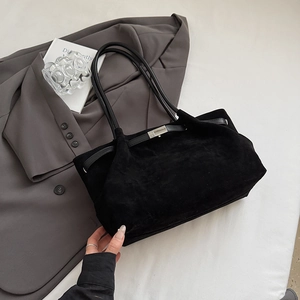Close-up of black matte suede shoulder bag with silver metal buckle and slim leather strap