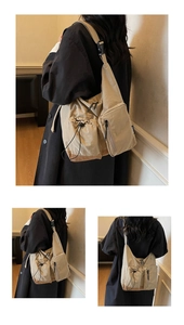 Detail of beige canvas crossbody bag featuring side zipper pocket and adjustable strap buckle