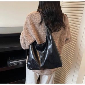 Model view of a black large capacity hobo bag showing its size and soft leather texture