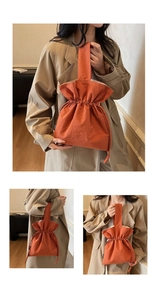 Detail van de oranje bucket bag van geplooid nylon met trekkoord en breed handvat