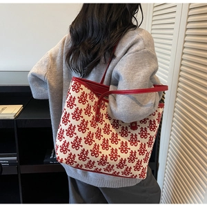Detail of red festive tote bag showing woven double happiness pattern and leather strap