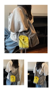Detail of grey crossbody bag with yellow drawstring pocket and adjustable wide strap
