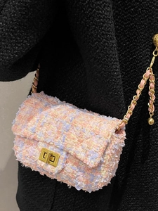 Pink and purple tweed chain crossbody bag with golden twist lock on black coat