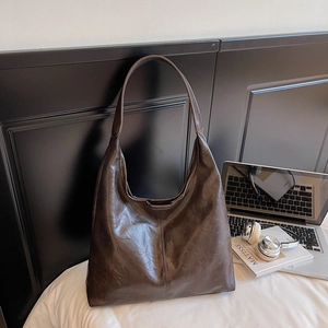 Detail of vintage dark brown faux leather tote bag with elegant oil wax texture