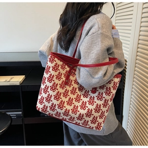Detail of red festive tote bag with double joy patterns and leather strap trim