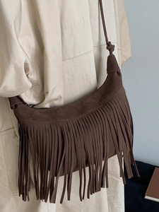 Brown suede crescent bag with fringe tassels and shoulder strap for autumn fashion