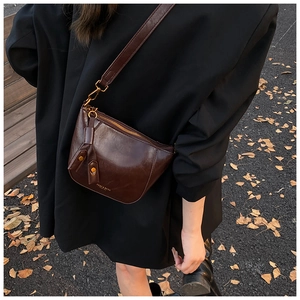 Detail of dark brown leather crescent bag with wide strap and vintage oil wax finish