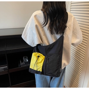 Detail of crossbody bag with yellow drawstring pocket and YOU JI BEAR brand label