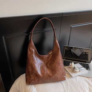 Detail view showing vintage textured brown leather and spacious interior of the tote bag
