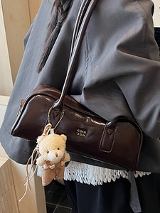 Dark brown patent leather Boston bag with a bear charm and gold logo lettering
