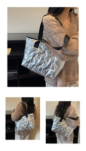 Detail of silver quilted tote bag with metallic finish and black woven strap on model