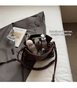 Detail view of large capacity dark brown leather bucket bag showing spacious interior storage