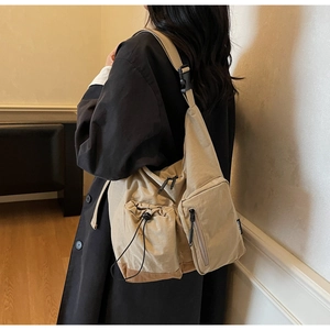 Detail of khaki nylon crossbody bag with functional drawstring pocket and sturdy strap buckle