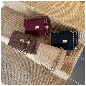 Detailed close-up of quilted velvet crossbody bags with golden ball chain straps