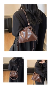 Detail view of brown leather bucket bag with unique spiral woven handle and drawstring