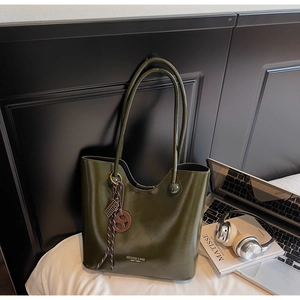 Olive green tote bag detail with vintage charm on white bedding with lifestyle props