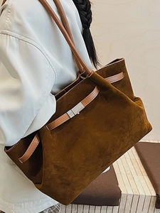 Minimalist dark brown matte suede bucket bag with leather strap and silver metal buckle