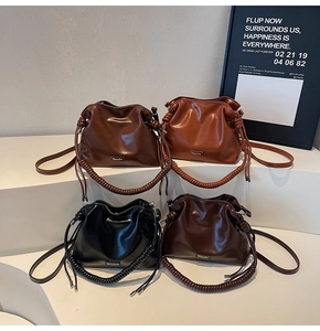 Detail of four colorful PU leather bucket bags with woven handles and drawstring tassels