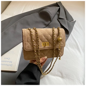 Detailed view of the gold ball metal chain and square turn-lock on the khaki suede bag