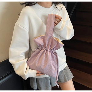 Detail van lila handtas met trekkoord, getextureerde nylon stof en geplooide sluiting