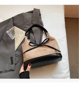 Vue détaillée du sac cabas en daim beige et cuir noir avec un petit nœud décoratif