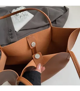 Detail view of the magnetic snap closure and interior texture on a tan tote bag
