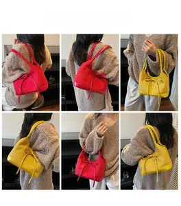 Détail de sacs cabas en daim rouge et jaune avec d'élégantes décorations de nœuds en cuir