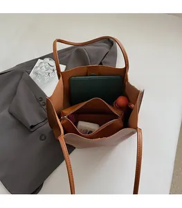 Interior view of brown leather tote bag with large capacity and matching zipper pouch