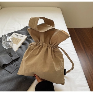 Vista dettagliata della borsa in tela beige a pieghe con coulisse ed etichetta