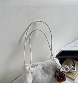 Détail du sac cabas en peluche blanche avec fines bandoulières et breloque léopard
