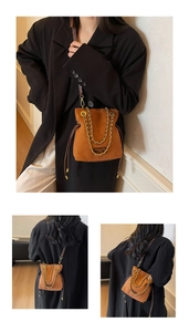 Détail du sac seau en daim marron avec chaîne dorée et fermeture par cordon de serrage