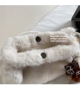 Détail du fermoir magnétique sécurisé sur un sac à main en peluche blanche douce