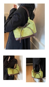 Détail du cabas en daim vert avec contraste en cuir marron et décoration de nœud élégante