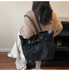 Detail showing vintage textured black tote bag with decorative buckle and matte finish